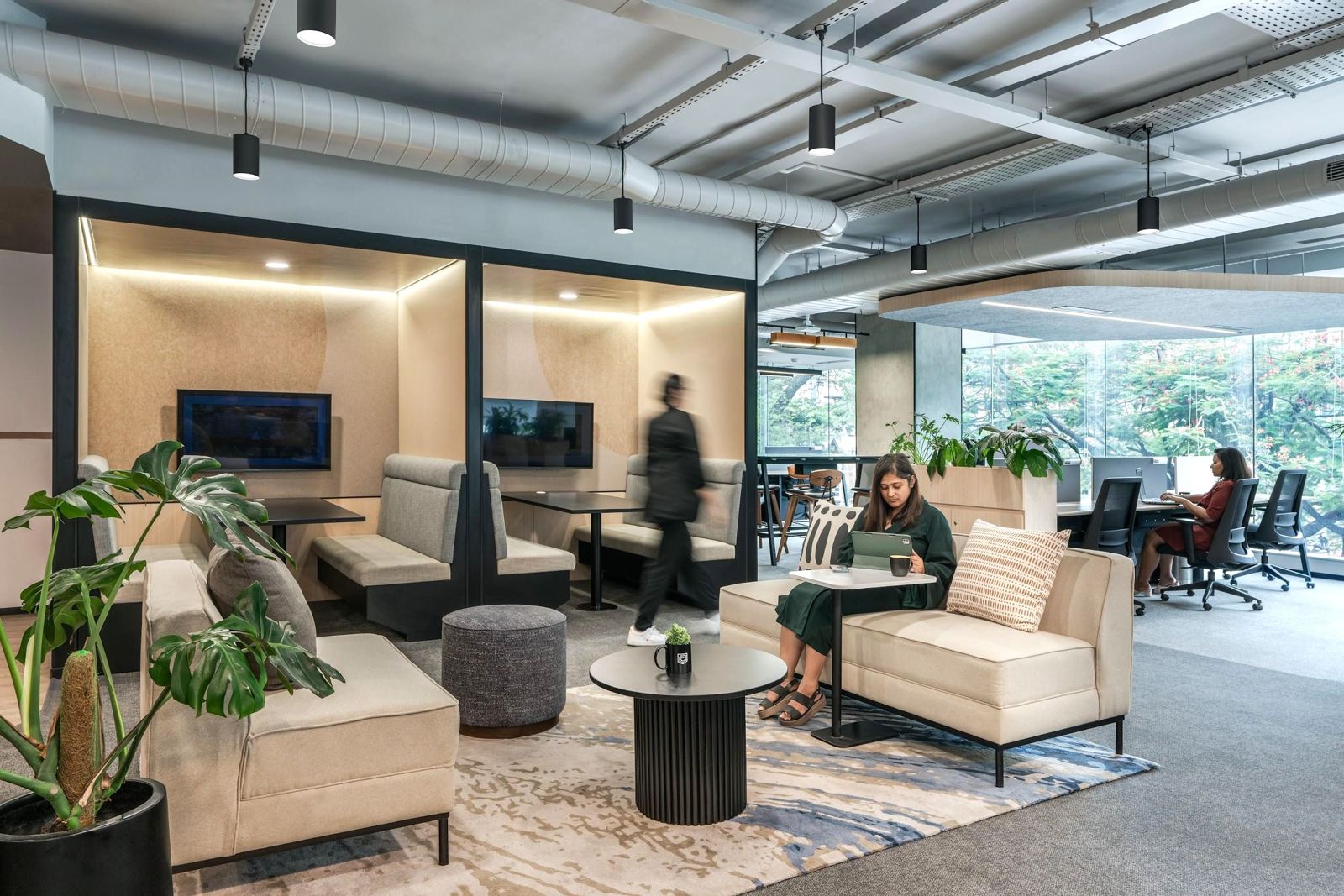 Lounge and open workspace with planting and floor-to-ceiling windows